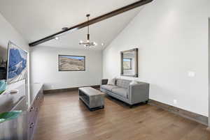 Living area featuring dark wood-type flooring, high vaulted ceiling, beamed ceiling, a chandelier, and recessed lighting
