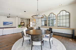 Dining room featuring dark wood-style flooring, a chandelier, recessed lighting, stairs, and ceiling fan