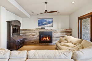 Living area featuring a glass covered fireplace, a ceiling fan, and recessed lighting