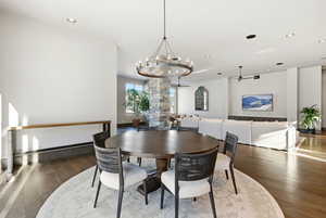 Dining space with dark wood finished floors, recessed lighting, a ceiling fan, and a chandelier