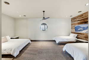 Carpeted bedroom with wood walls, recessed lighting, and an accent wall