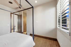 Bedroom with multiple windows, ceiling fan, wood finished floors, and recessed lighting