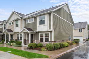 Craftsman-style home with board and batten siding, stone siding, and roof with shingles