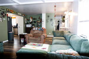 Living area featuring dark wood-type flooring and baseboards