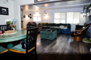 Dining space with wood finished floors and beamed ceiling