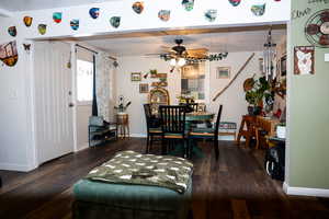 Dining area with dark wood-type flooring and a ceiling fan