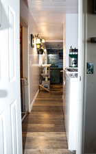 Corridor with dark wood-type flooring and washing machine and dryer