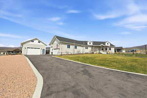 View of front of house with board and batten siding, asphalt driveway, covered porch, a mountain view, and an outbuilding