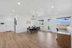 Dining room with light wood-style flooring, recessed lighting, and arched walkways