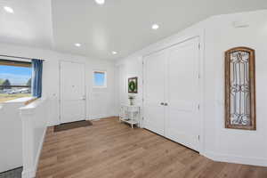 Foyer entrance featuring light wood finished floors and recessed lighting