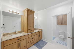 Full downstairs bathroom with double vanity and toilet