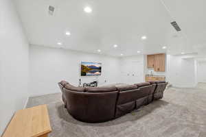 Family room featuring light colored carpet, wet bar, and recessed lighting