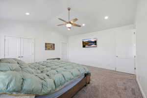 Primary bedroom featuring carpet floors, a ceiling fan, vaulted ceiling, a closet, and recessed lighting