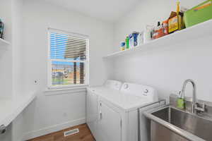 Laundry area with independent washer and dryer and dark wood-style flooring