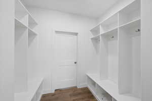 Mudroom featuring dark wood finished floors and baseboards