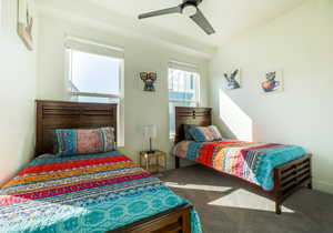 Carpeted bedroom with ceiling fan and baseboards