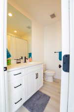 Full bath featuring vanity, light wood-type flooring, a shower with shower curtain, and recessed lighting
