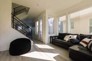 Living area with stairway and light wood-type flooring