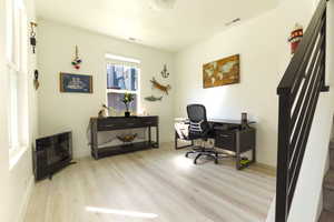 Office space with light wood-type flooring and baseboards