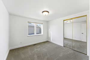 Unfurnished bedroom with light colored carpet and a closet