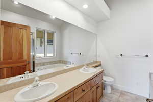 Full bath with double vanity, a bath, a shower stall, light tile patterned flooring, and recessed lighting