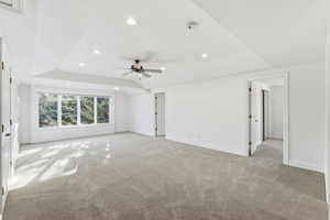 Unfurnished living room with recessed lighting, a tray ceiling, ceiling fan, and light colored carpet