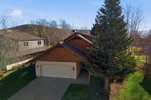 View of front facade featuring an attached garage, concrete driveway, and a front lawn
