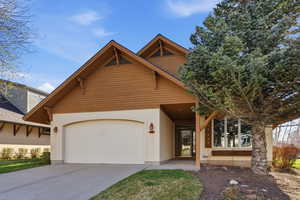 View of front facade featuring driveway, a garage, and stucco siding