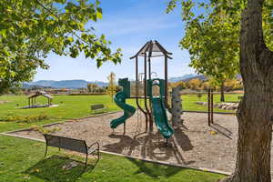 Community play area with a yard and a mountain view