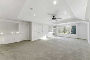 Unfurnished living room featuring recessed lighting, ceiling fan, built in shelves, and light carpet