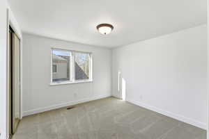 Unfurnished bedroom featuring light colored carpet and a closet