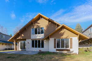Back of property with stucco siding and a lawn