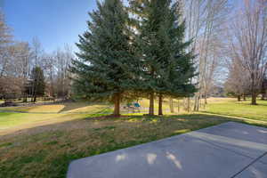 View of grassy yard with a patio area