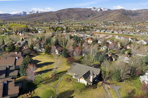 Aerial view of property and surrounding area with a mountain backdrop and nearby suburban area