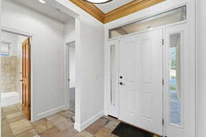 Entryway with stone tile flooring and baseboards