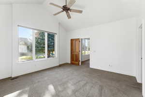 Unfurnished bedroom with carpet floors, vaulted ceiling, and a ceiling fan