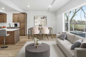 Living room with light wood-type flooring and recessed lighting