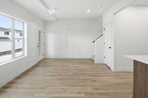 Foyer entrance with light wood finished floors and recessed lighting