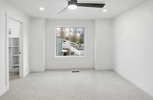 Empty room featuring light colored carpet, ceiling fan, and recessed lighting
