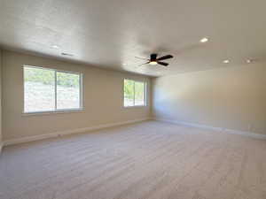 Unfurnished room with light carpet, recessed lighting, ceiling fan, and a textured ceiling