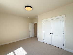 Unfurnished bedroom with carpet flooring and a closet