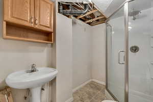 Bathroom with a stall shower and baseboards