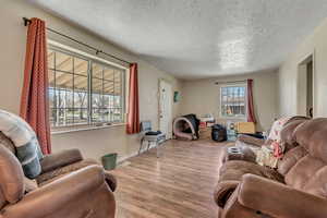 Living area featuring wood finished floors and a textured ceiling
