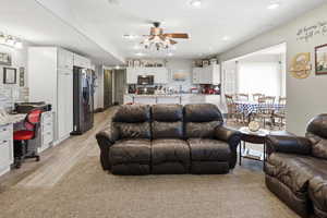Living room with ceiling fan, a desk, recessed lighting, and light wood-type flooring