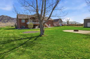 View of yard featuring a mountain view, a balcony, an outdoor fire pit, and a patio area