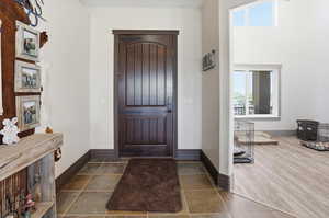 Foyer with a high ceiling and dark wood-style floors
