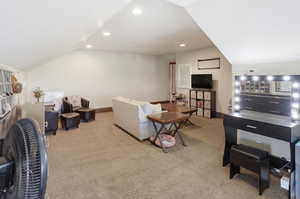 Lofted ceiling, light carpet, and recessed lighting