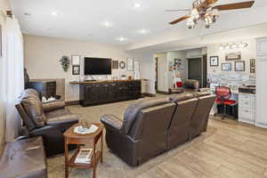 Living area with ceiling fan, light wood-style flooring, and recessed lighting