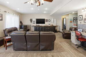 Living room with light wood-type flooring, recessed lighting, and a desk