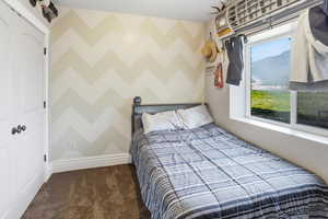 Bedroom with dark colored carpet, a closet, and a mountain view